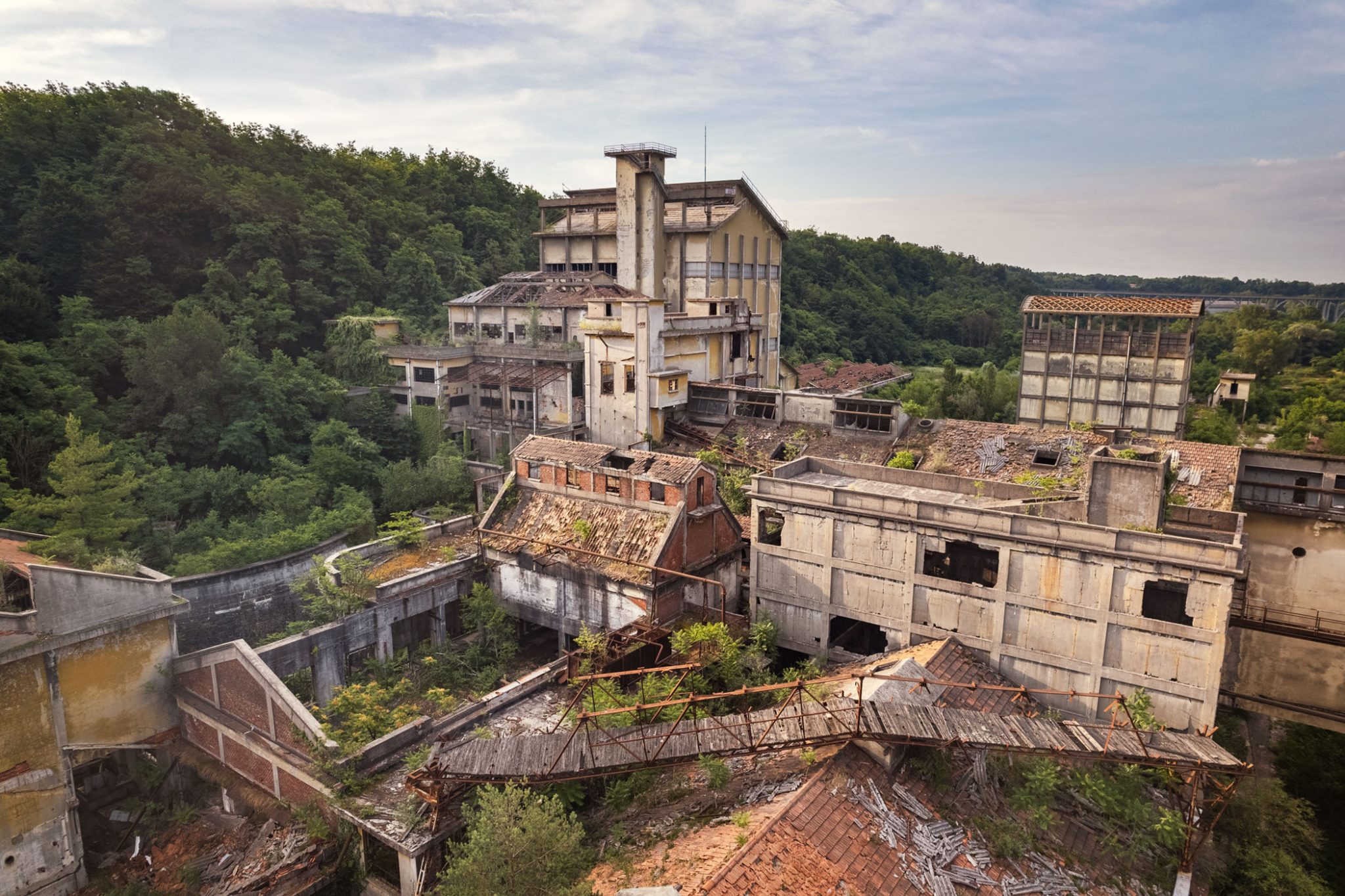 Aerial view of a former paper factory in a wooded valley in Italy