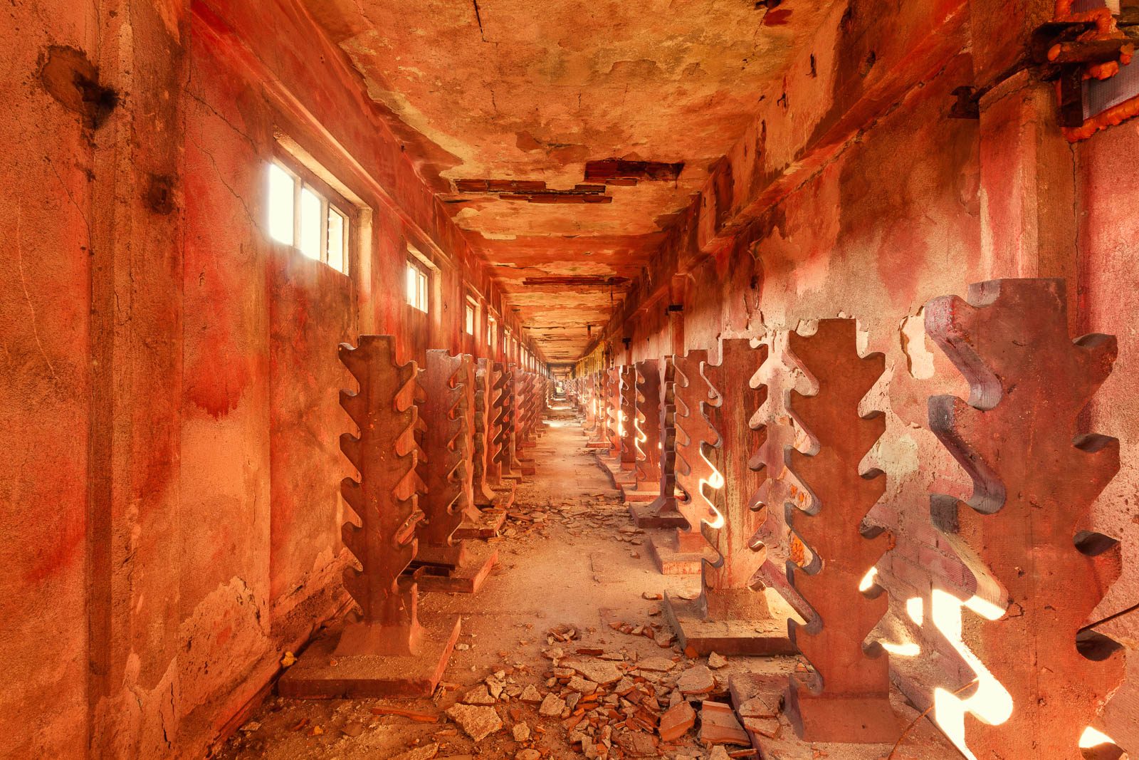 Corridor with jagged metal elements in warm light in a decommissioned textile factory in Italy