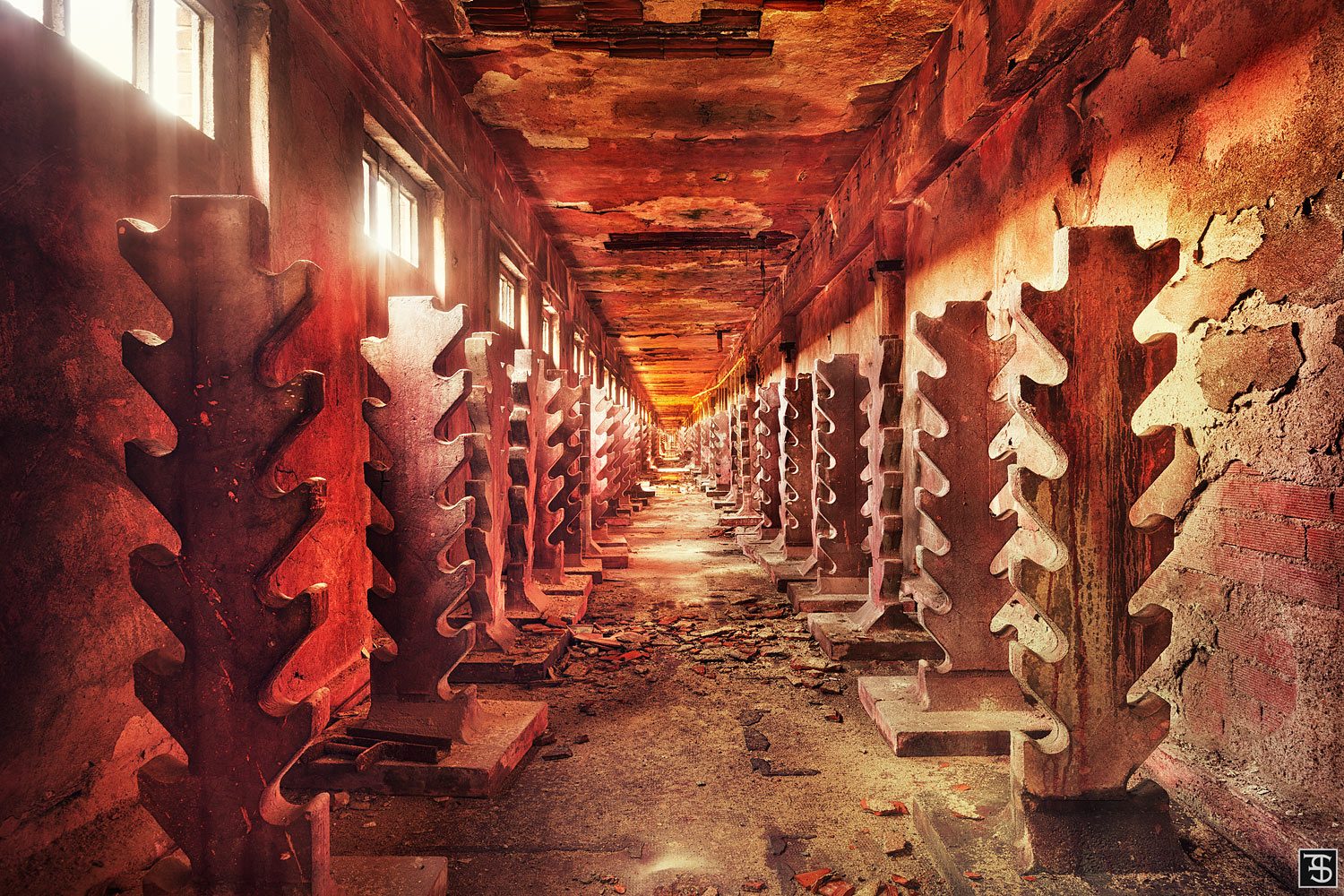 Gear-shaped metal structures in warm light in a decommissioned textile factory in Italy