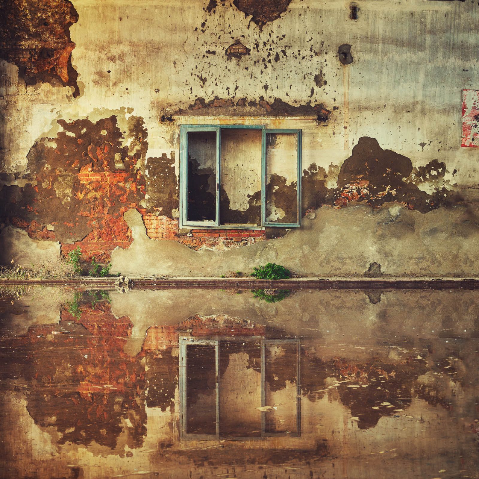 Window frame reflected in water in a factory in Italy