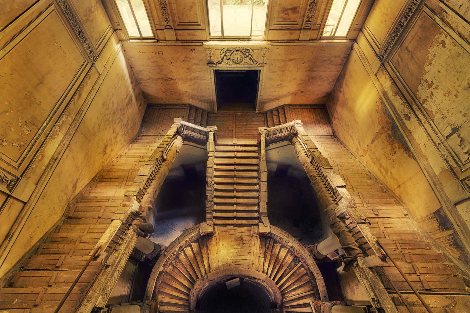 View from below of a wooden staircase arrangement in an abandoned grand hotel in Italy