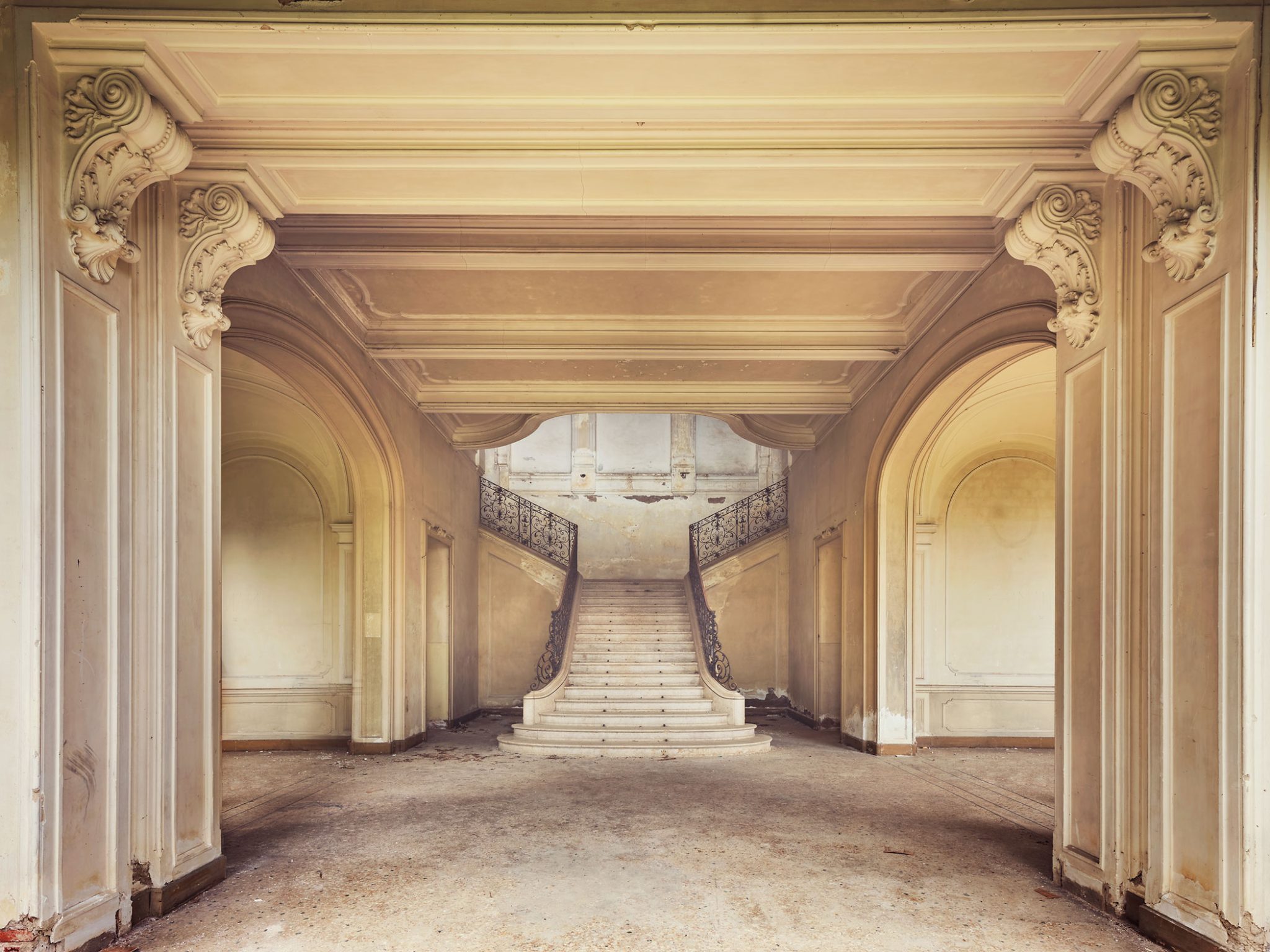 Symmetrische Doppeltreppe, gerahmt von einem Torbogen, in einer Villa in Italien