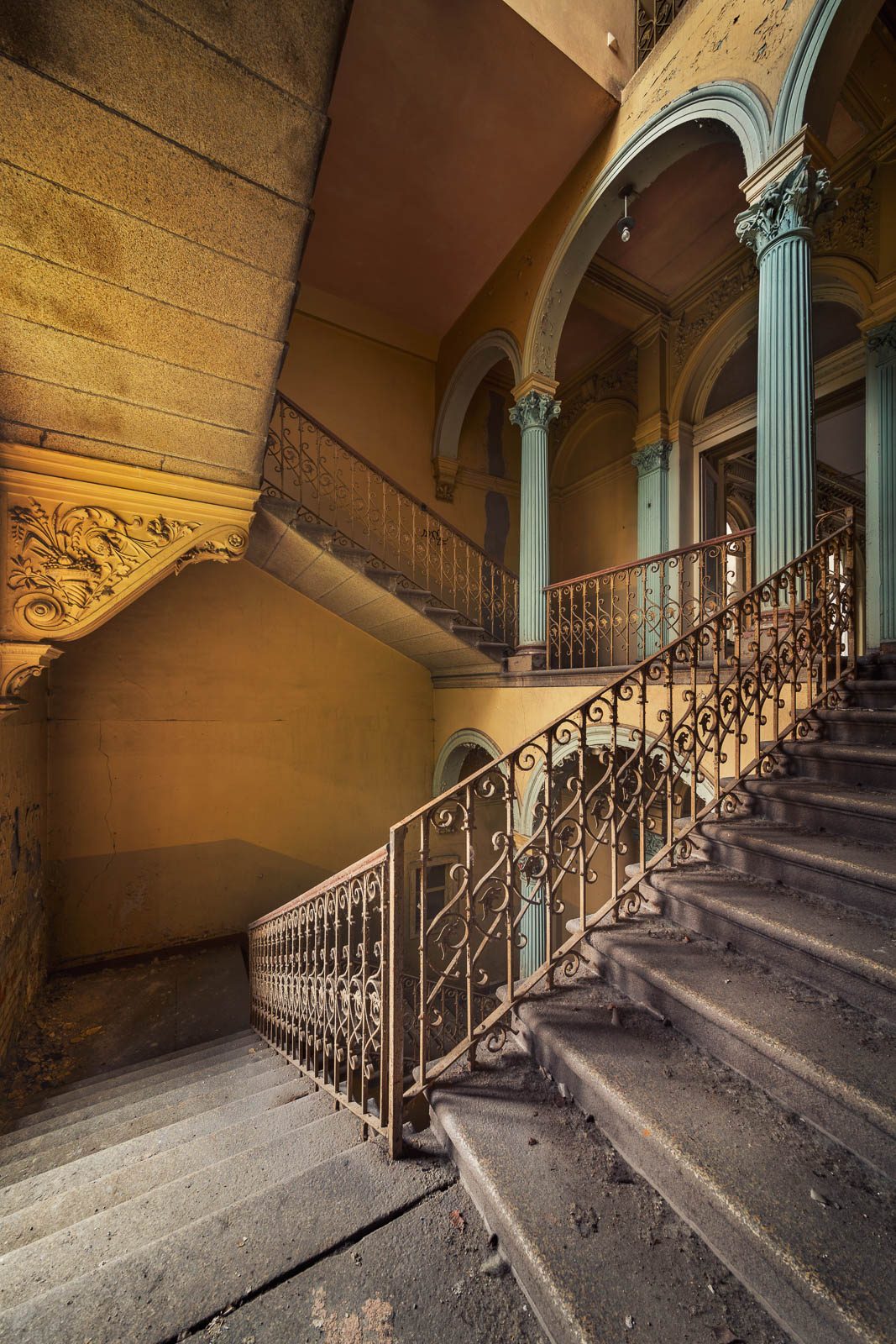 Treppenhaus mit türkisfarbenen Säulen und Arkaden in einer herrschaftlichen Villa in Deutschland