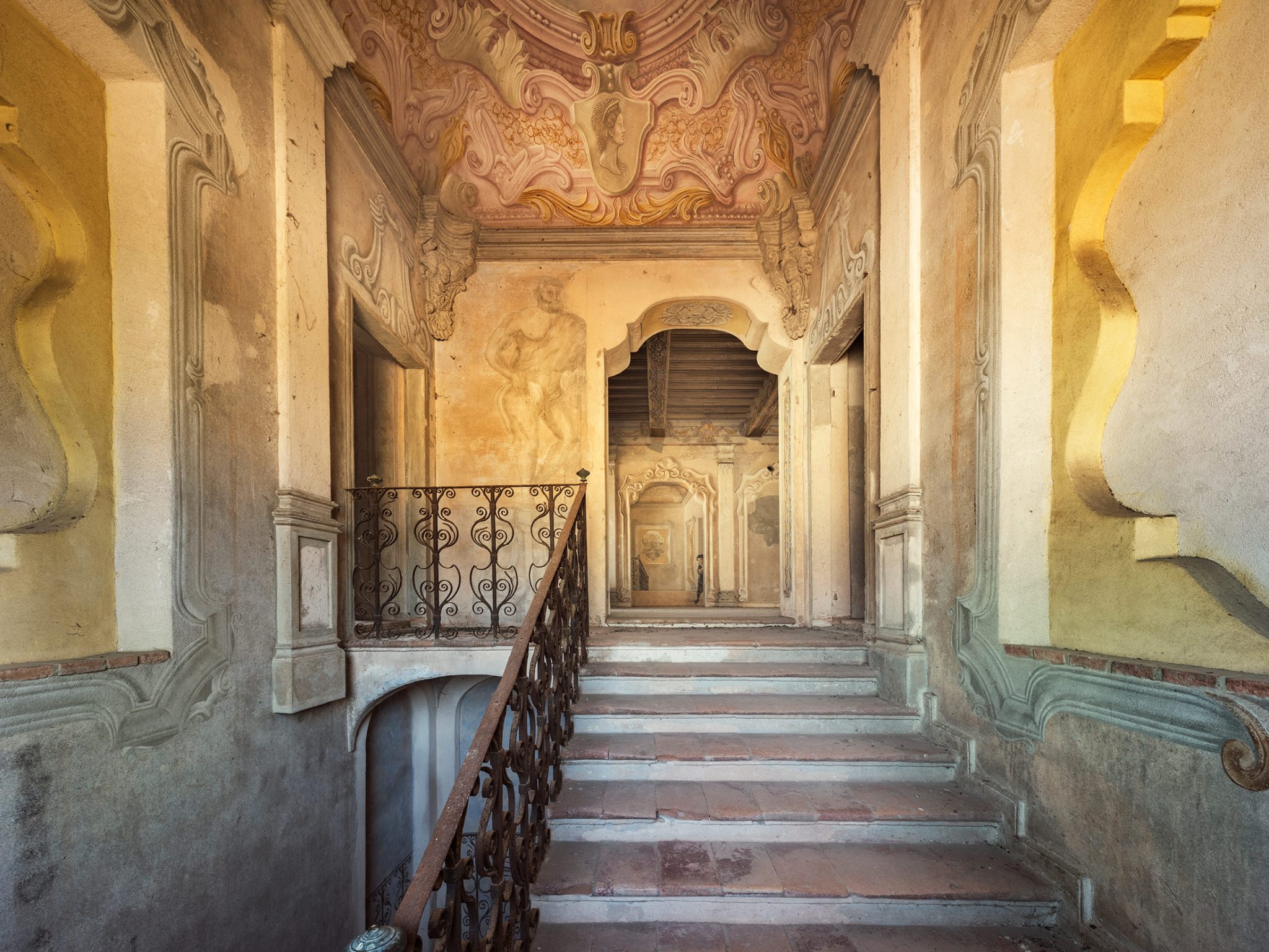 Vaulted hallway with wall paintings in a forgotten palace in Italy