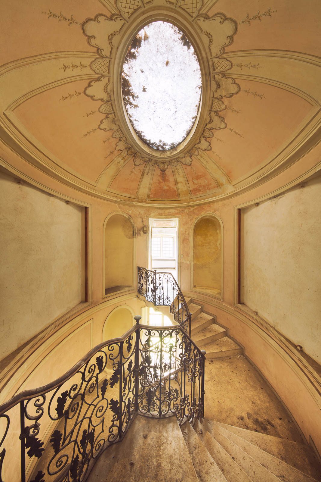 Oval dome with a skylight above a spiral staircase in a forgotten villa in Italy