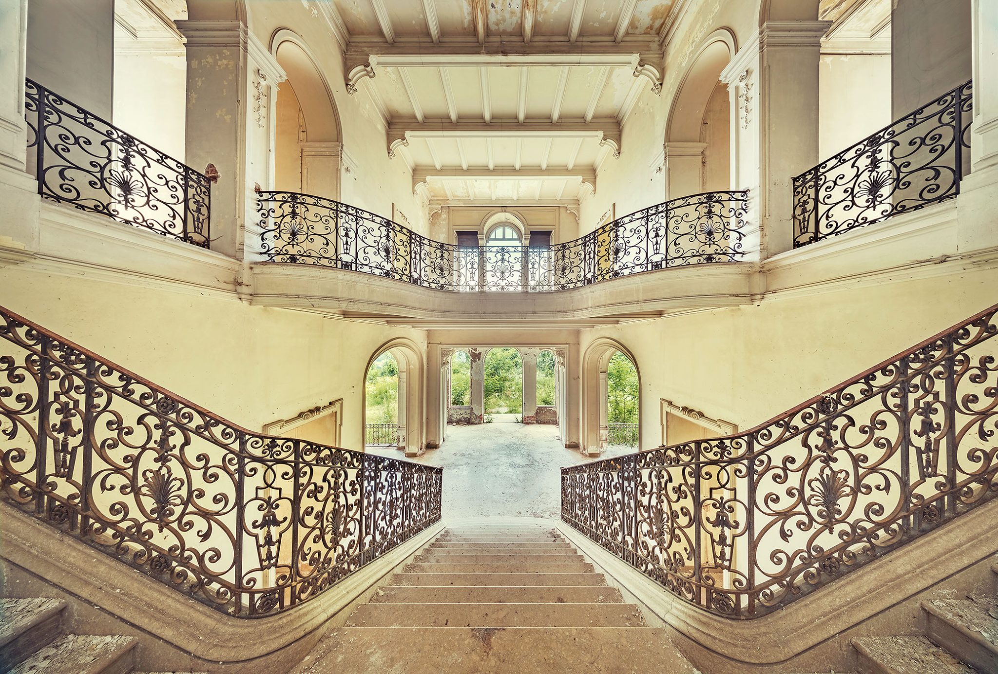 Zweistöckiges Treppenhaus mit schmiedeeisernen Balustraden in einer verlassenen Villa in Italien
