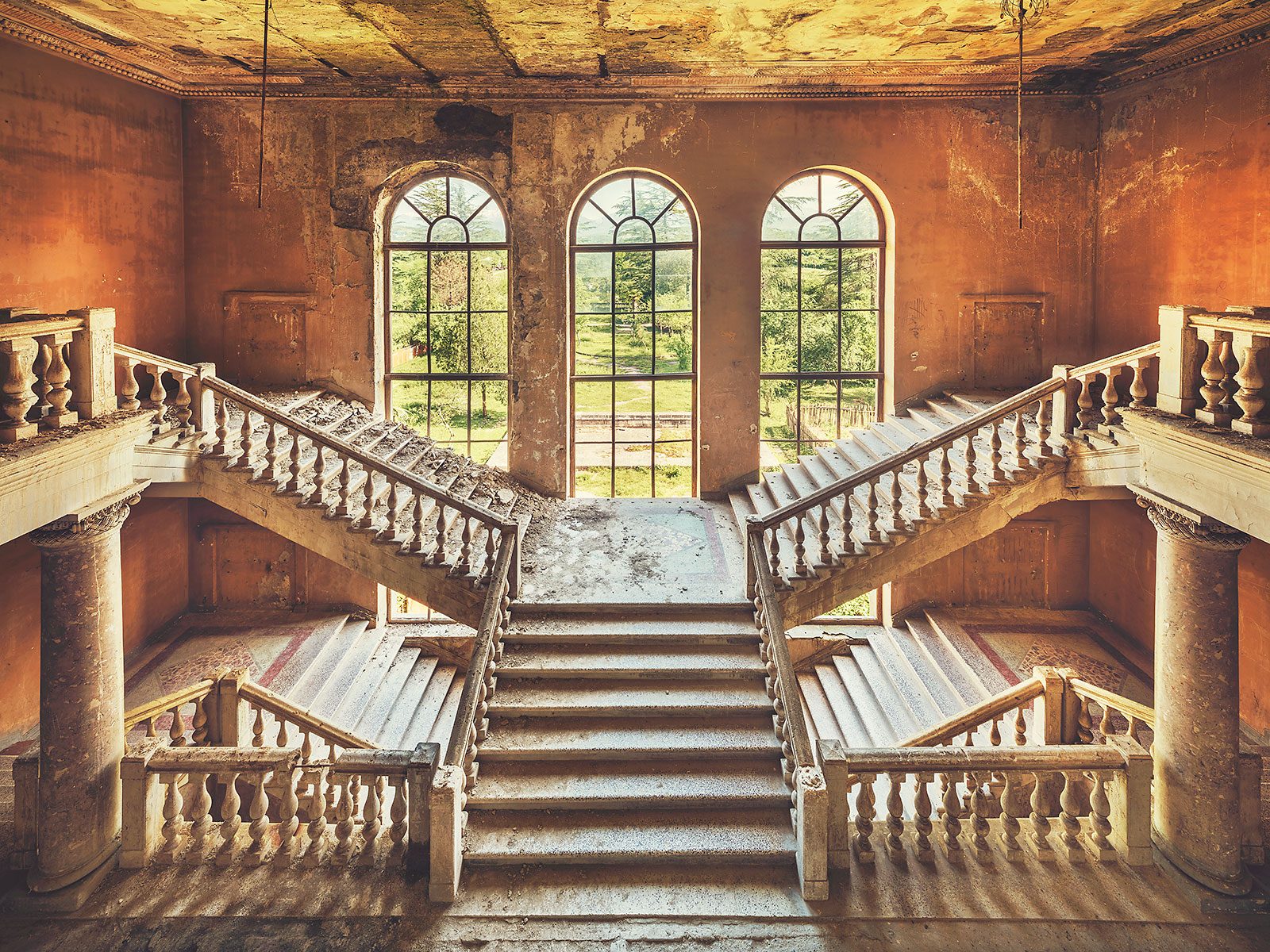 Symmetrische Treppenanlage vor drei hohen Fenstern in einem verlassenen Sanatorium in Georgien