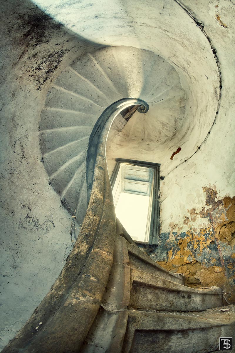 Blick von oben in eine spiralförmige Treppe in einem Château in Frankreich