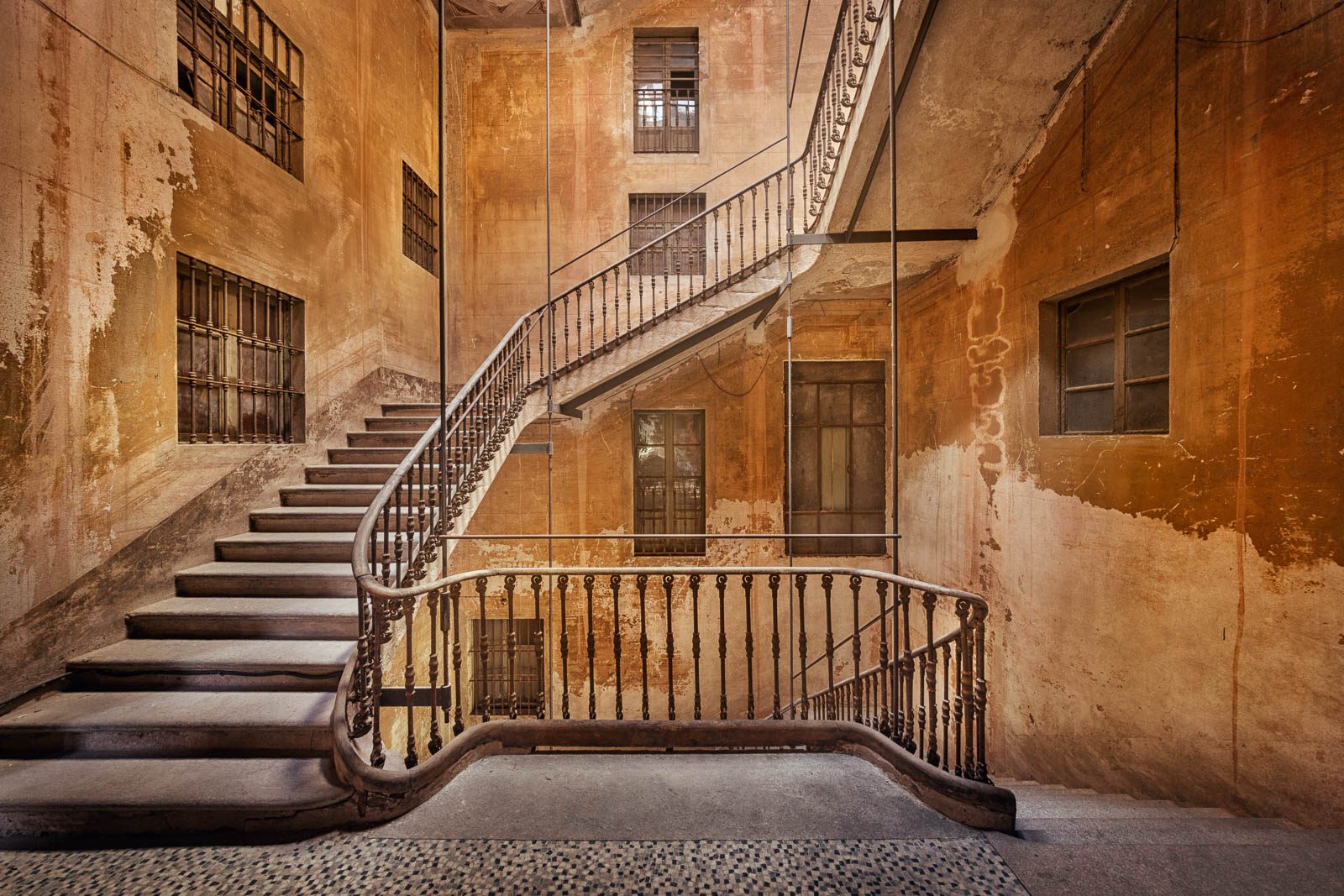 Freistehende Treppe an ockerfarbener Fassade in einem historischen Palazzo in Italien