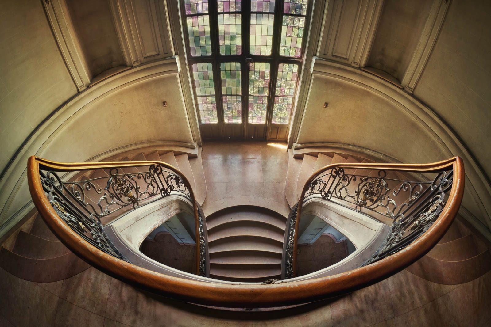 Symmetrical wooden staircase with a curved railing in a château in Belgium
