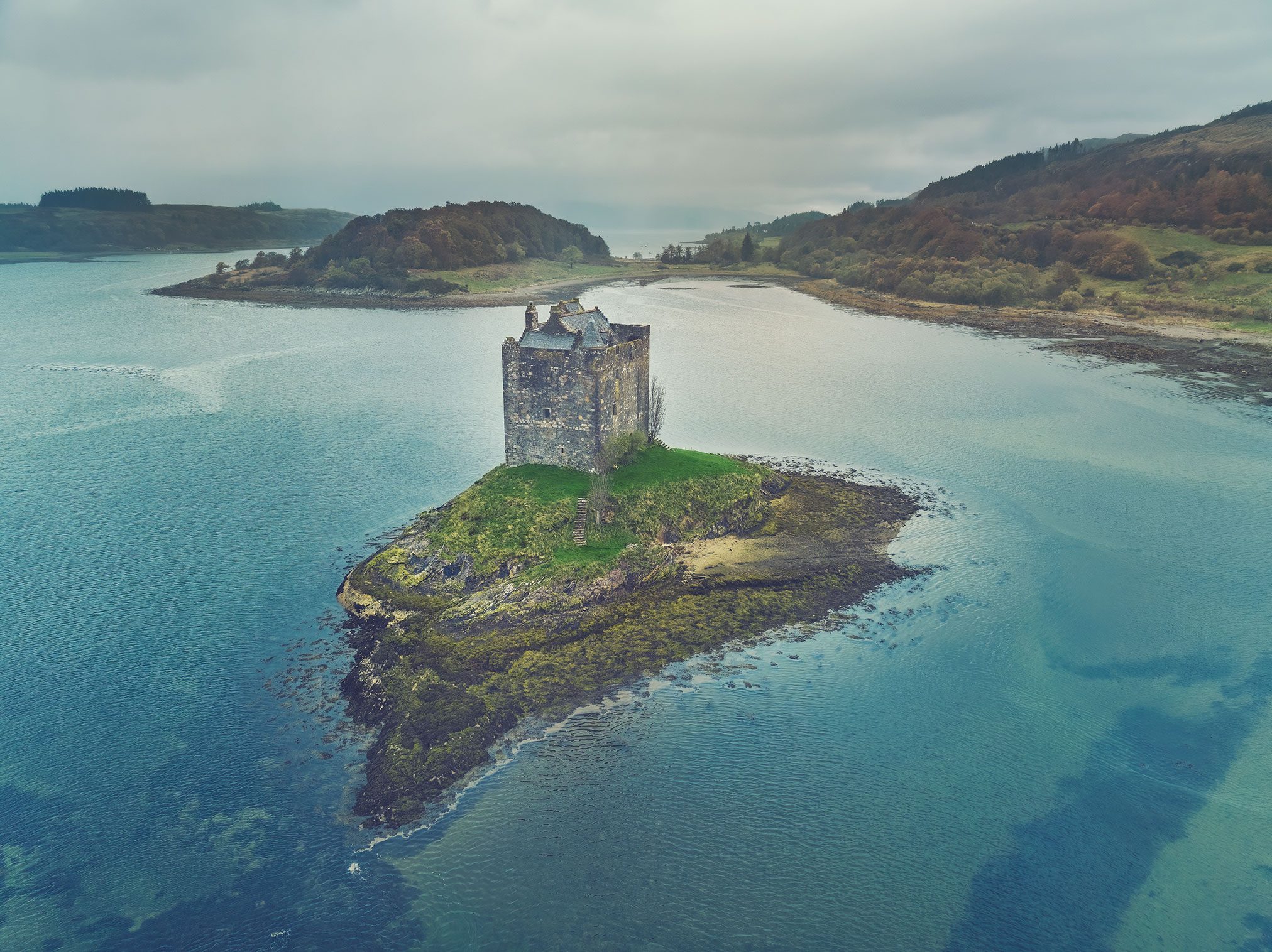 Tower house on an islet beside adjoining rock outcrops, Scotland