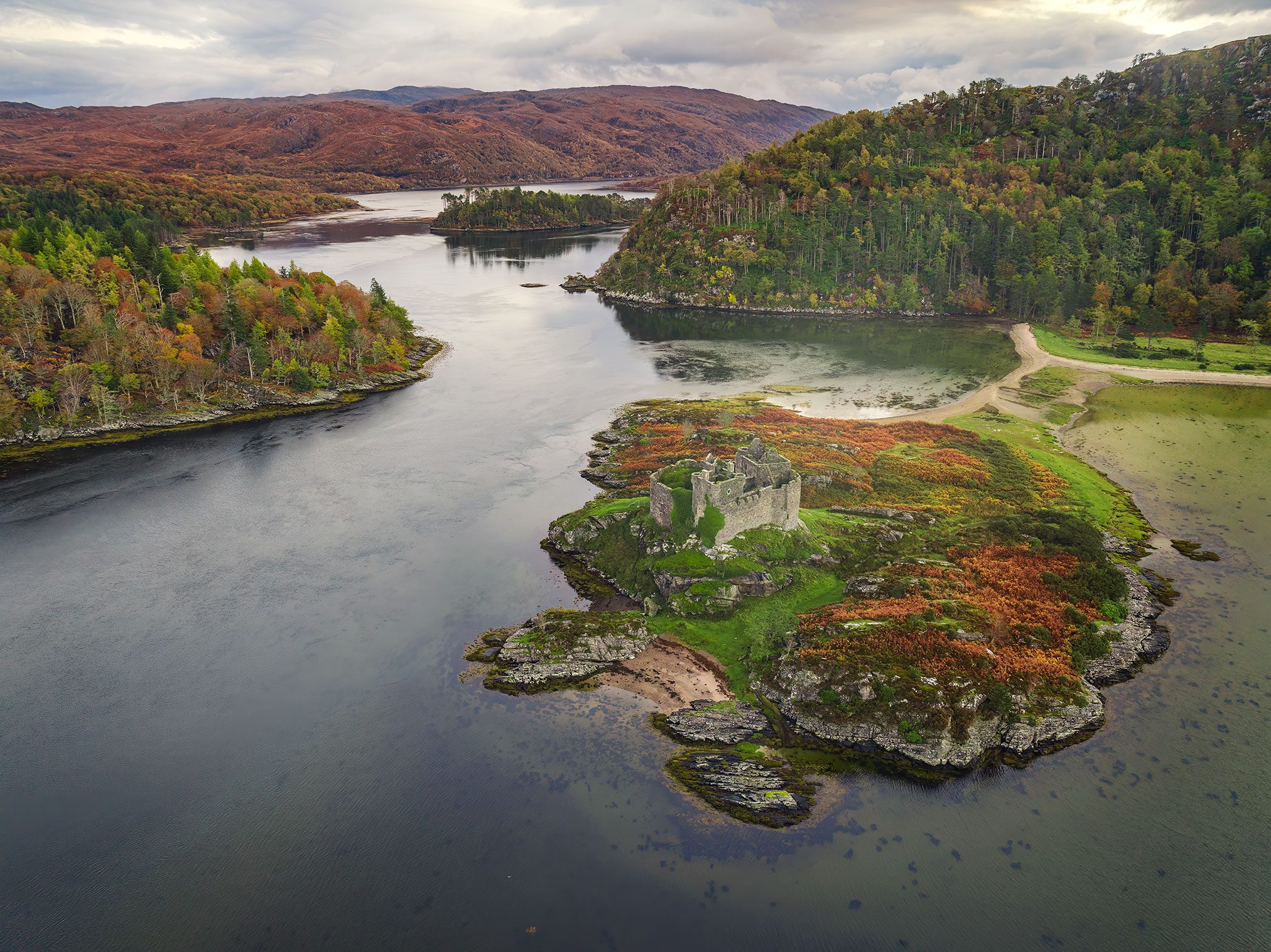 Castle ruin on an island in an autumn loch, Scotland