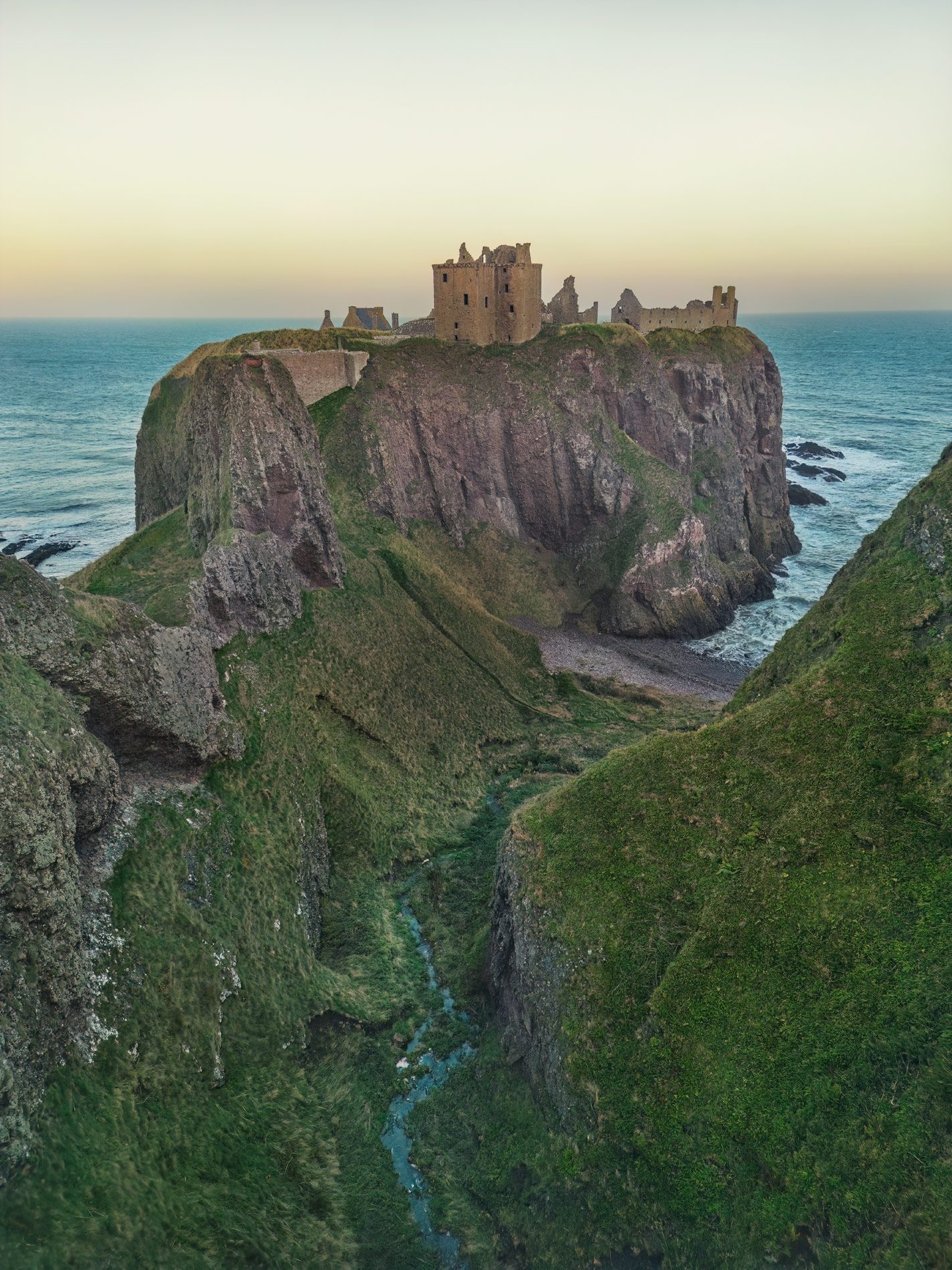 Castle ruin on a headland in golden light, Scotland