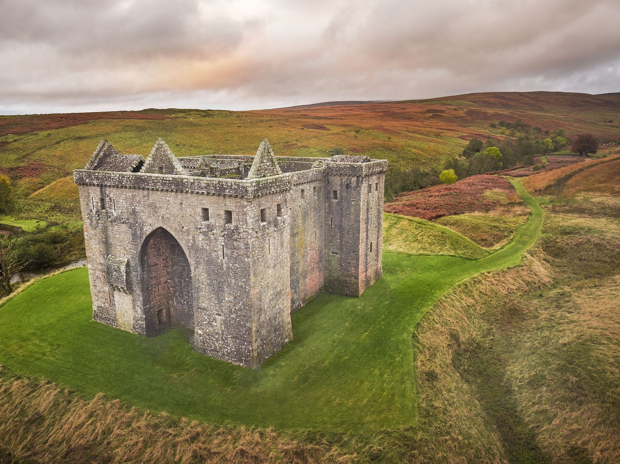 Massive keep on a grass mound on moorland, Scotland