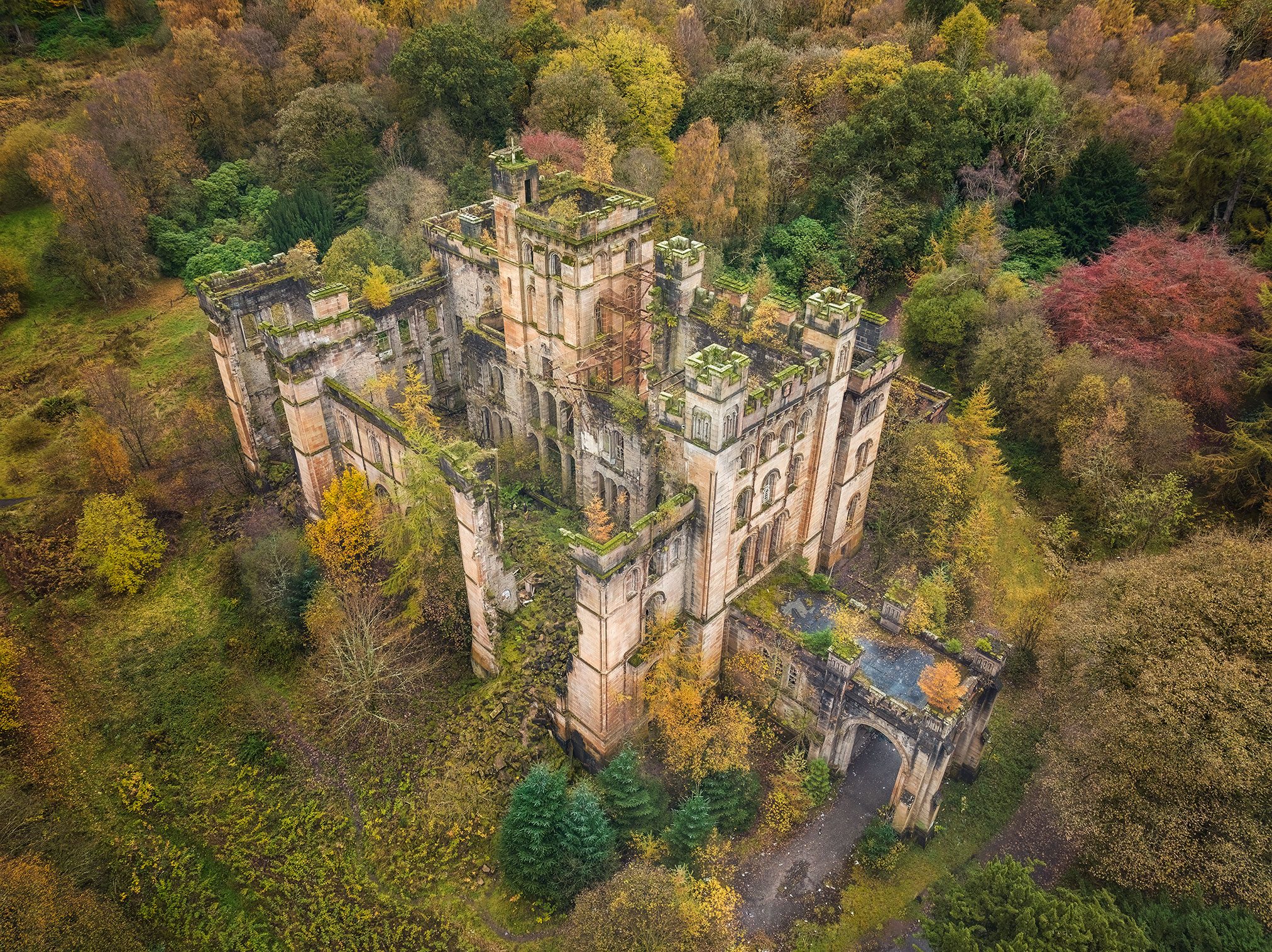 Sandstein-Castle mit Torbogen im Herbstwald, Schottland