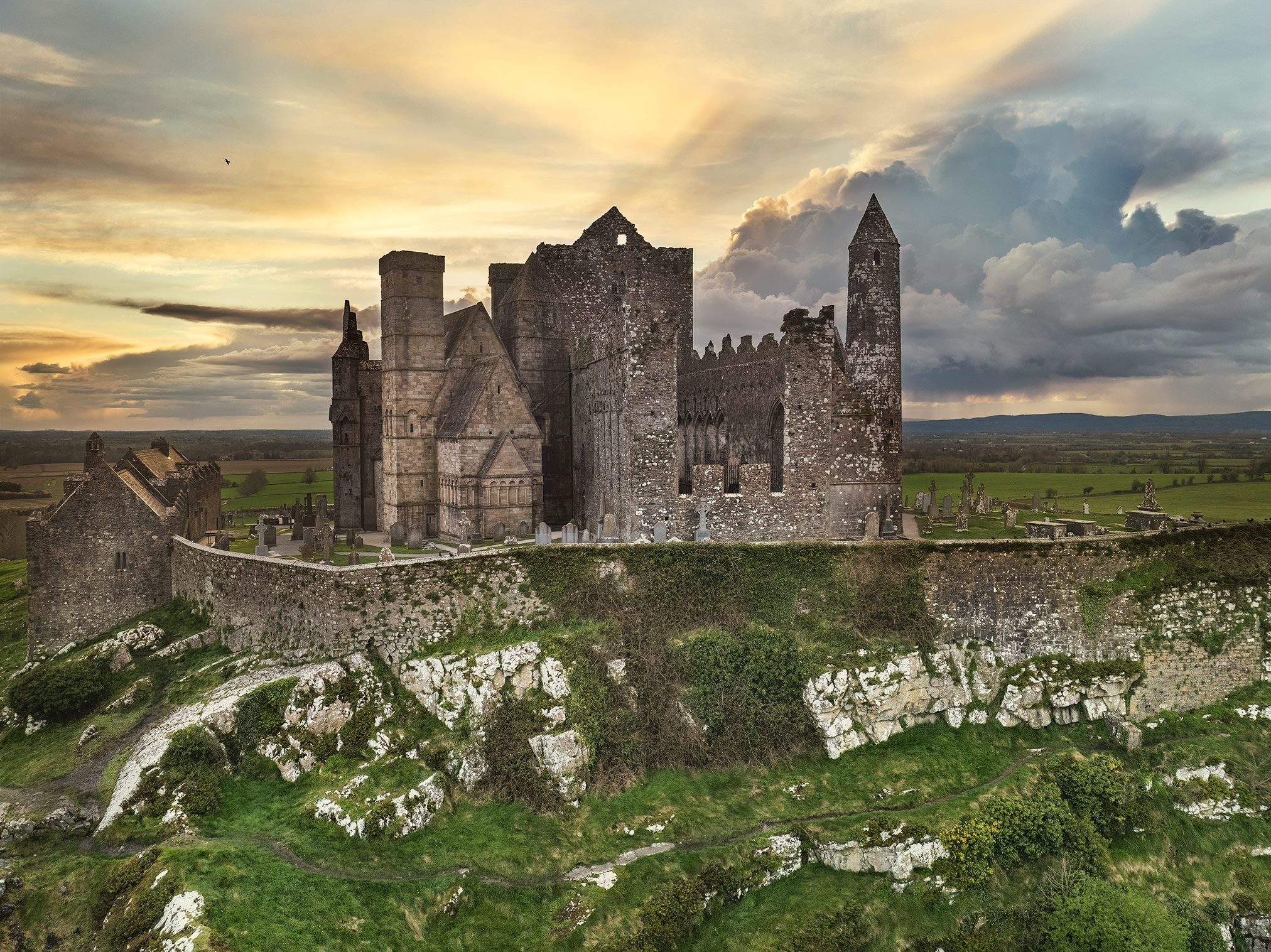 Kirchliche Ruinenanlage mit Rundturm auf Hügel, Irland