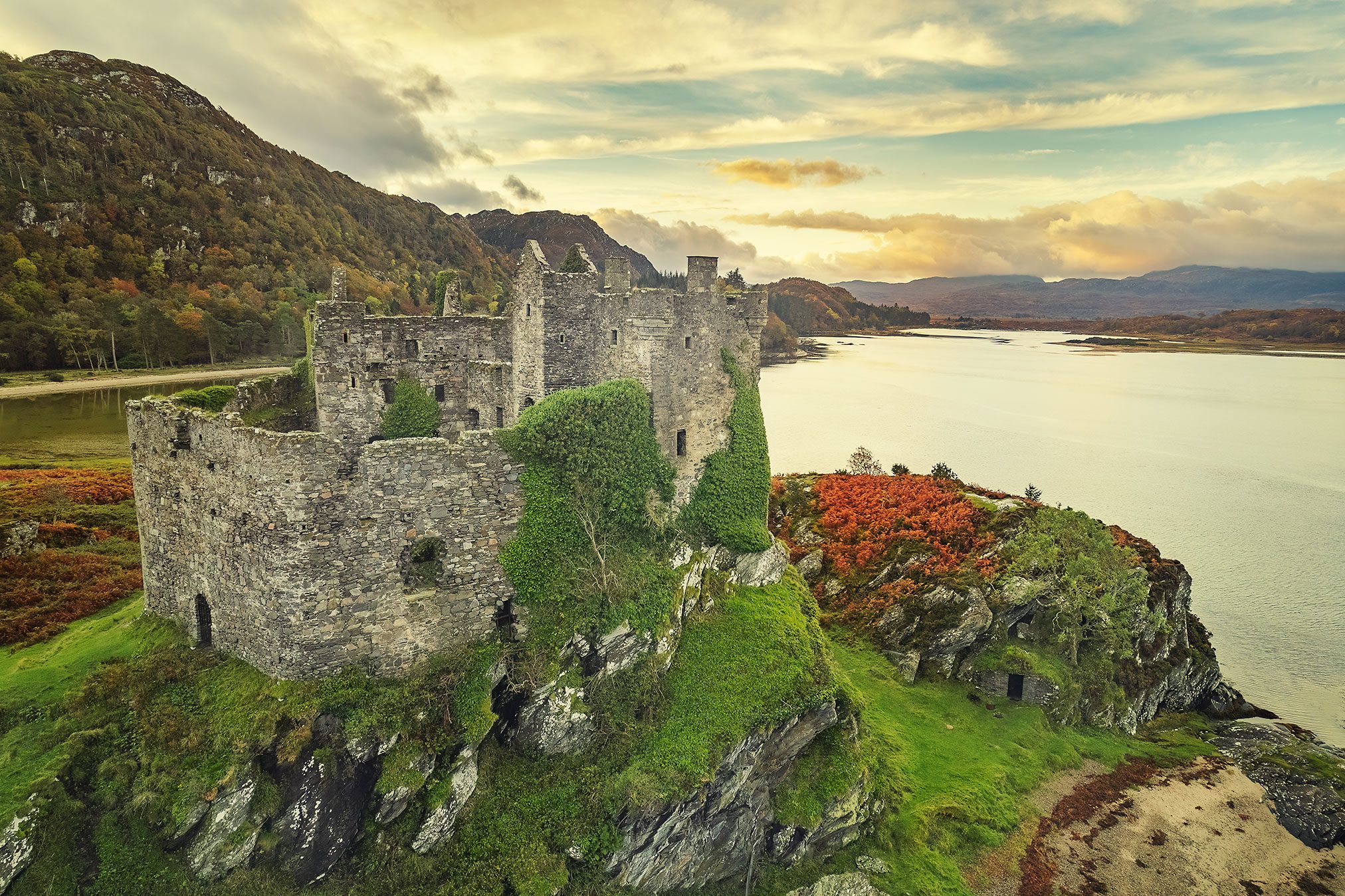Castle ruin on a rocky promontory in evening light, Scotland