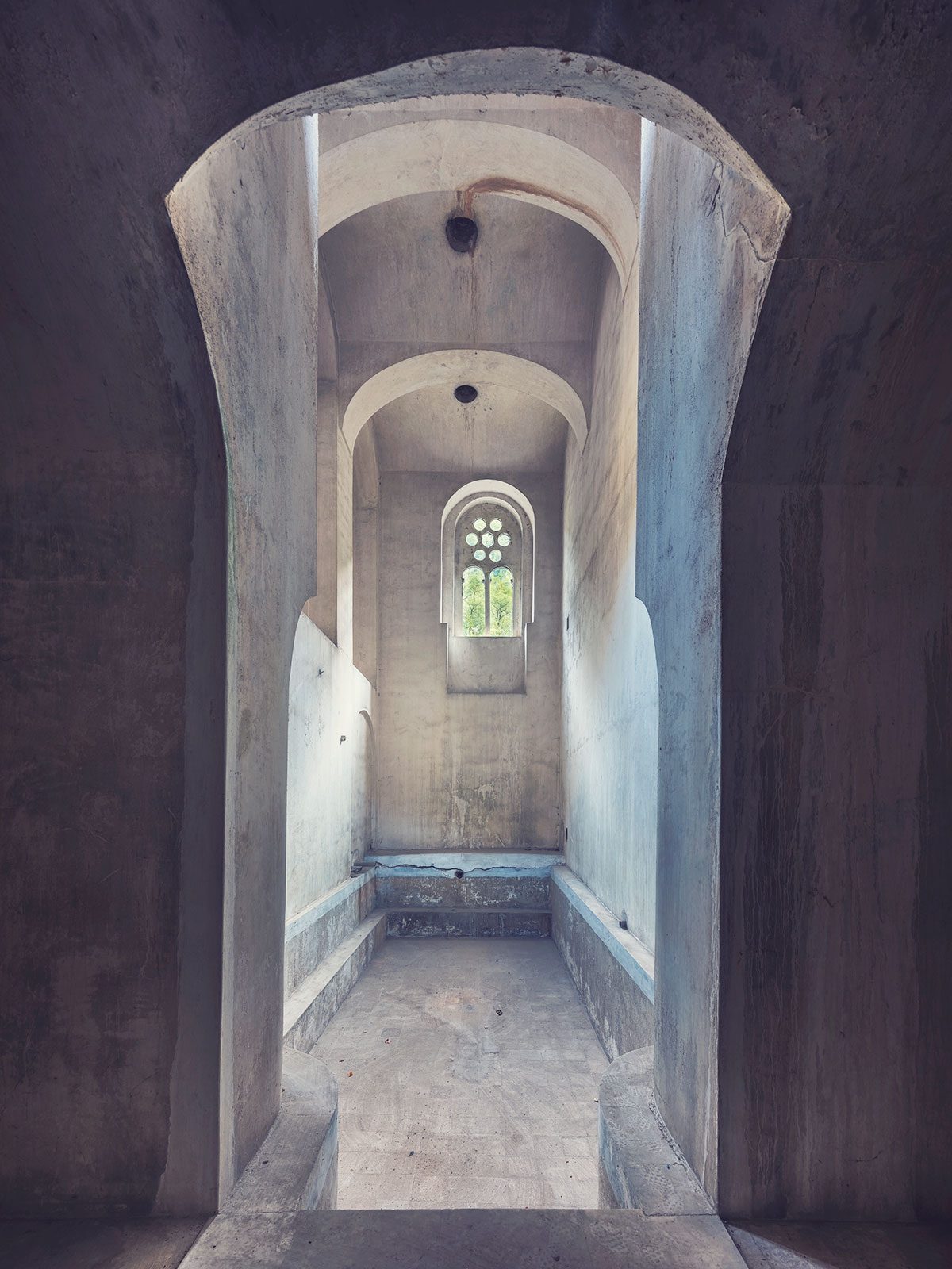 Schmaler Gewölbegang mit rundem Fenster in einem historischen Badehaus in Rumänien