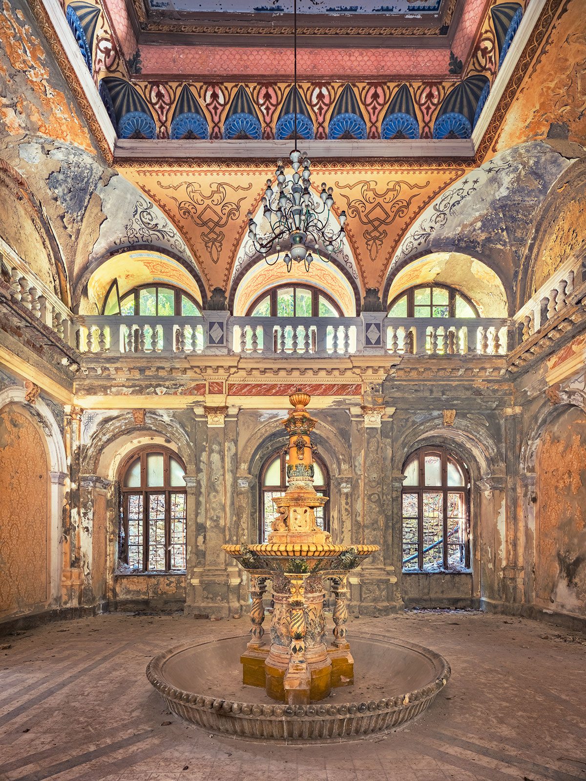 Fountain beneath a painted dome with a gallery in a historic bathhouse in Romania