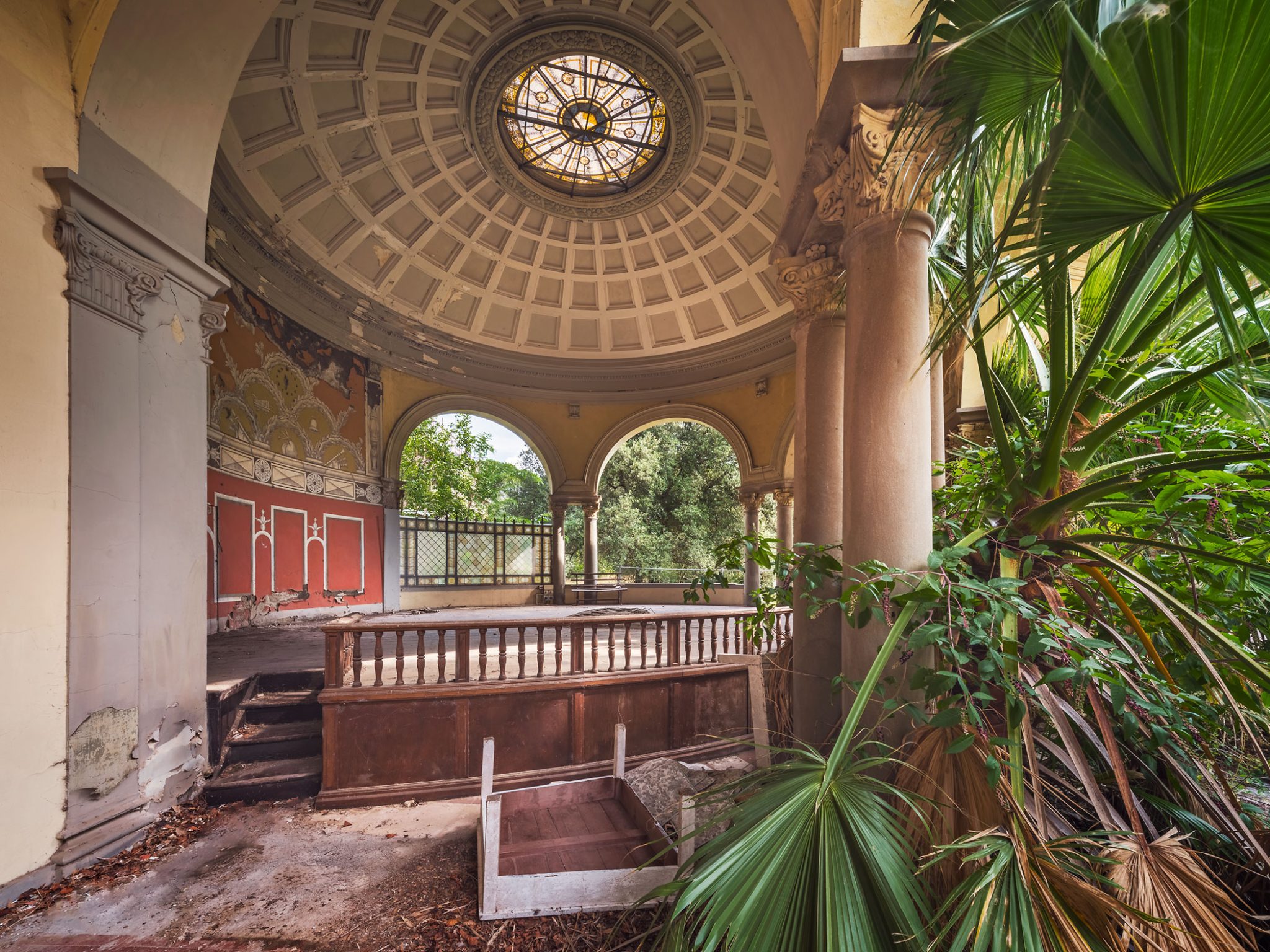 Colonnaded loggia with a domed ceiling and stained-glass skylight in a derelict spa building in Italy