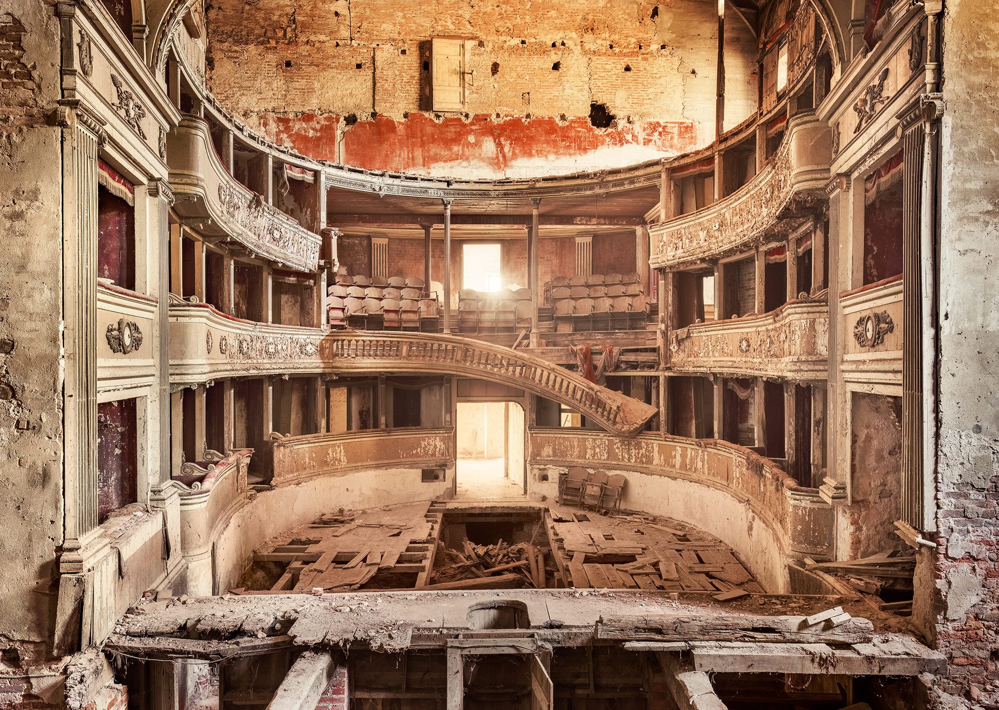 Decaying theatre with an open brick ceiling and collapsed floor in Italy