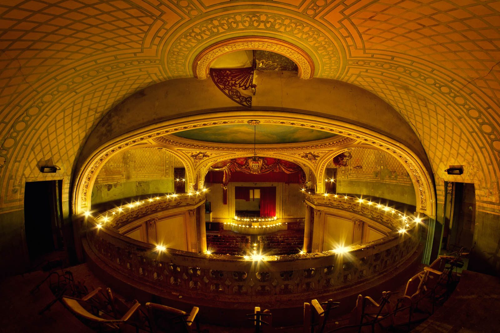 Oval theatre hall with gilded tiers and a string of lights by candlelight in France