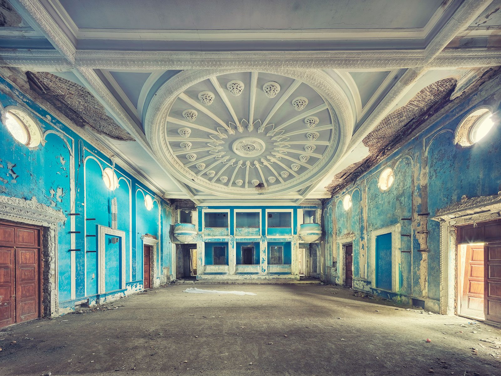 Blue-painted hall with a round ceiling rosette in a derelict theatre