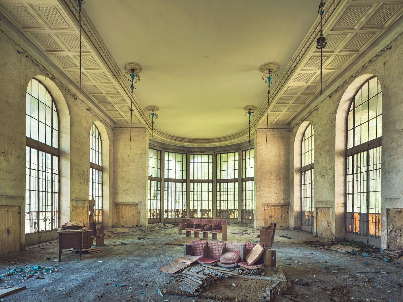 Hall with tall arched windows and overturned upholstered furniture in a sanatorium in Georgia