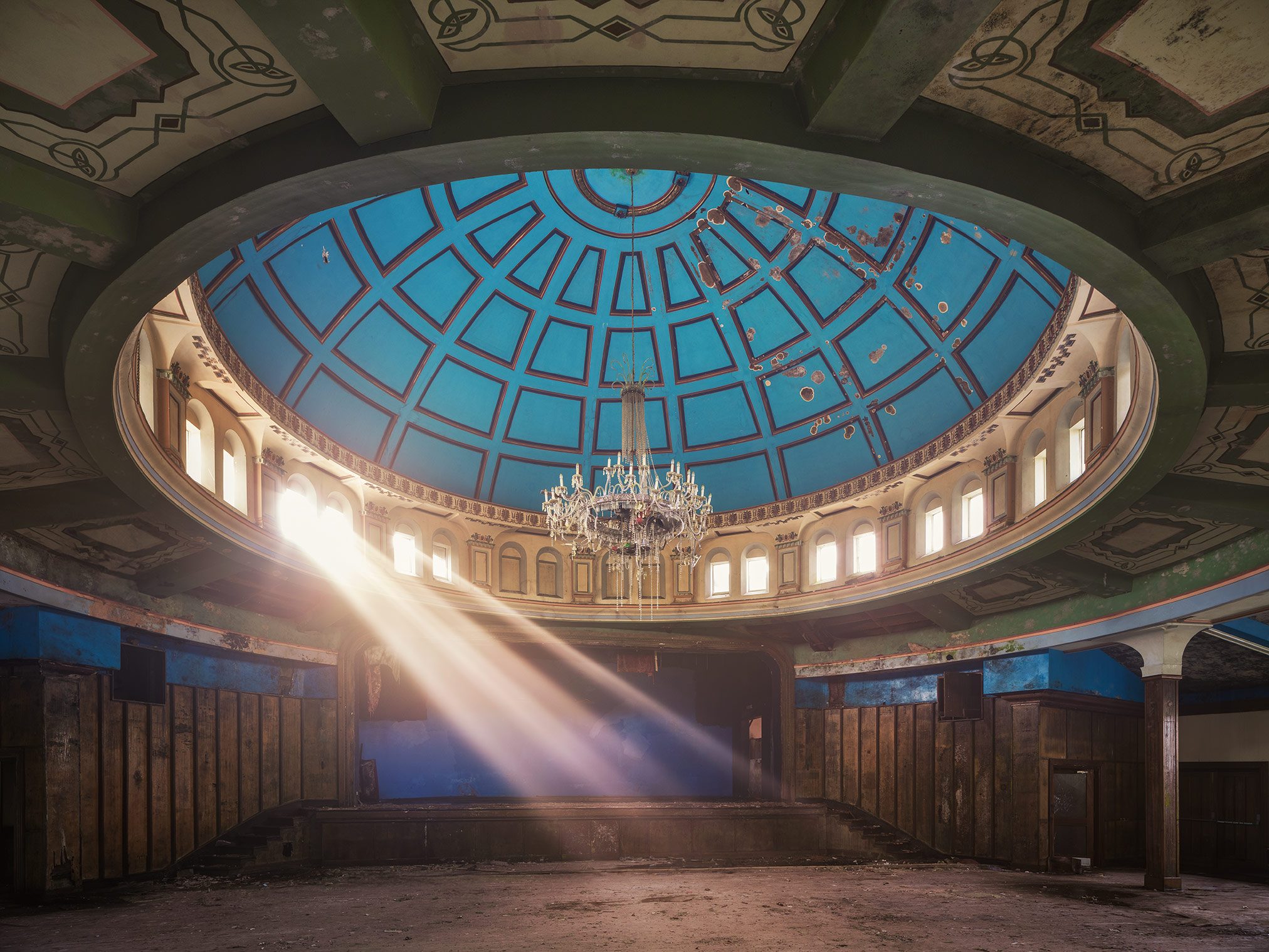 Domed hall with blue ceiling fresco and chandelier in a derelict dance hall in Northern Ireland