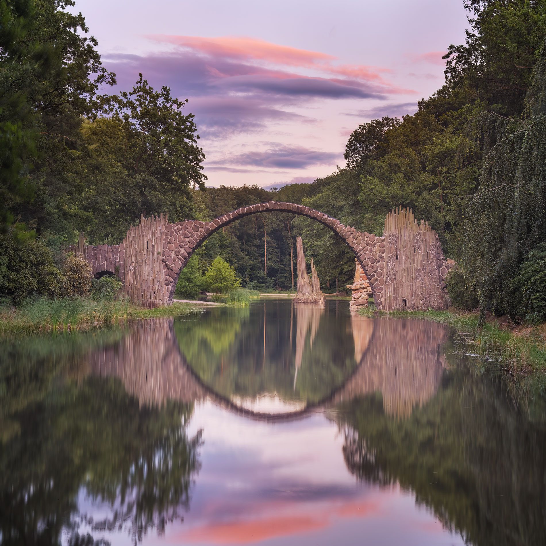 Bogenbrücke mit Kreisspiegelung bei Sonnenuntergang in Deutschland
