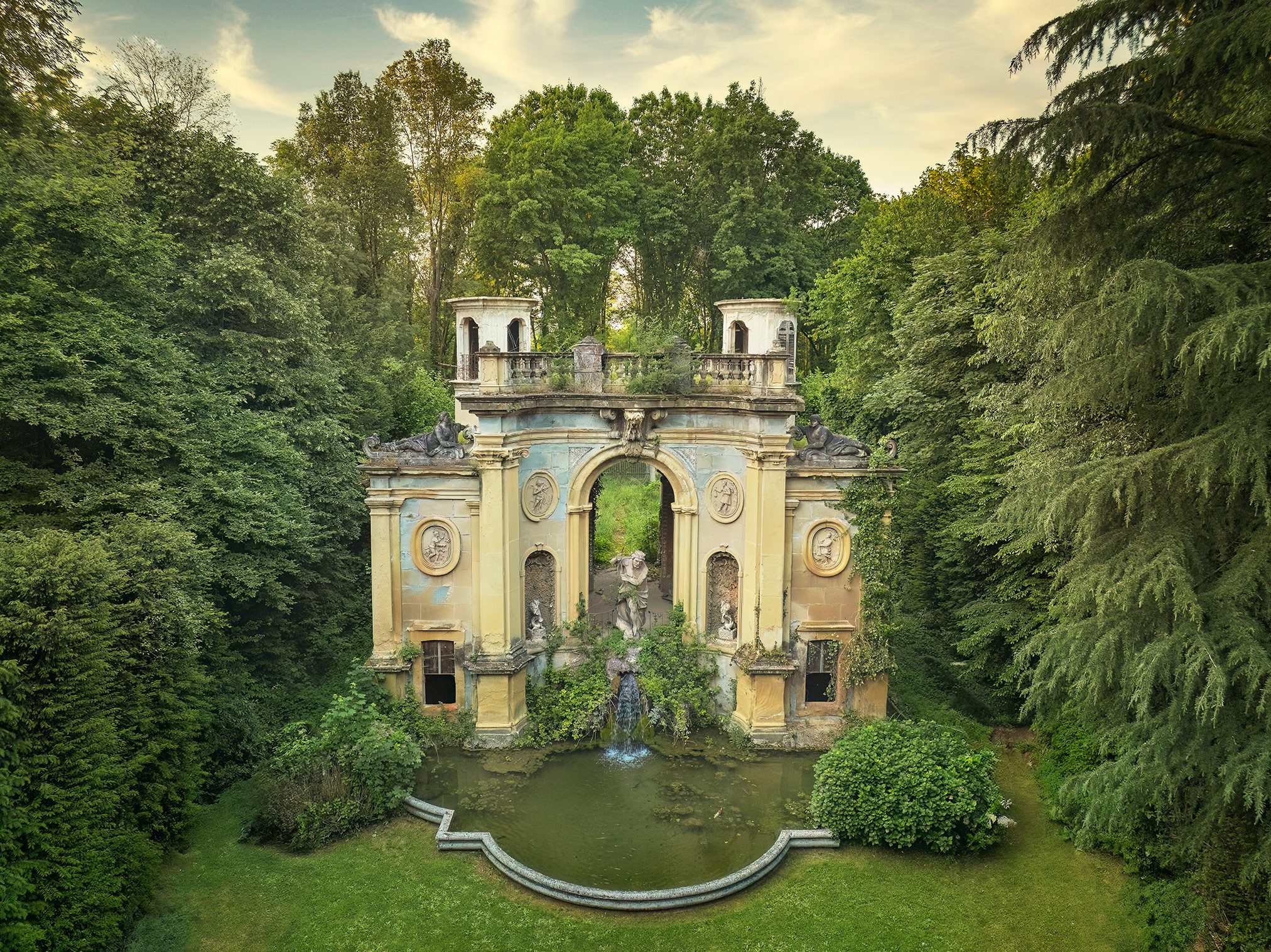 Barockes Nymphäum mit Wasserbecken vor einer Waldkulisse in Italien