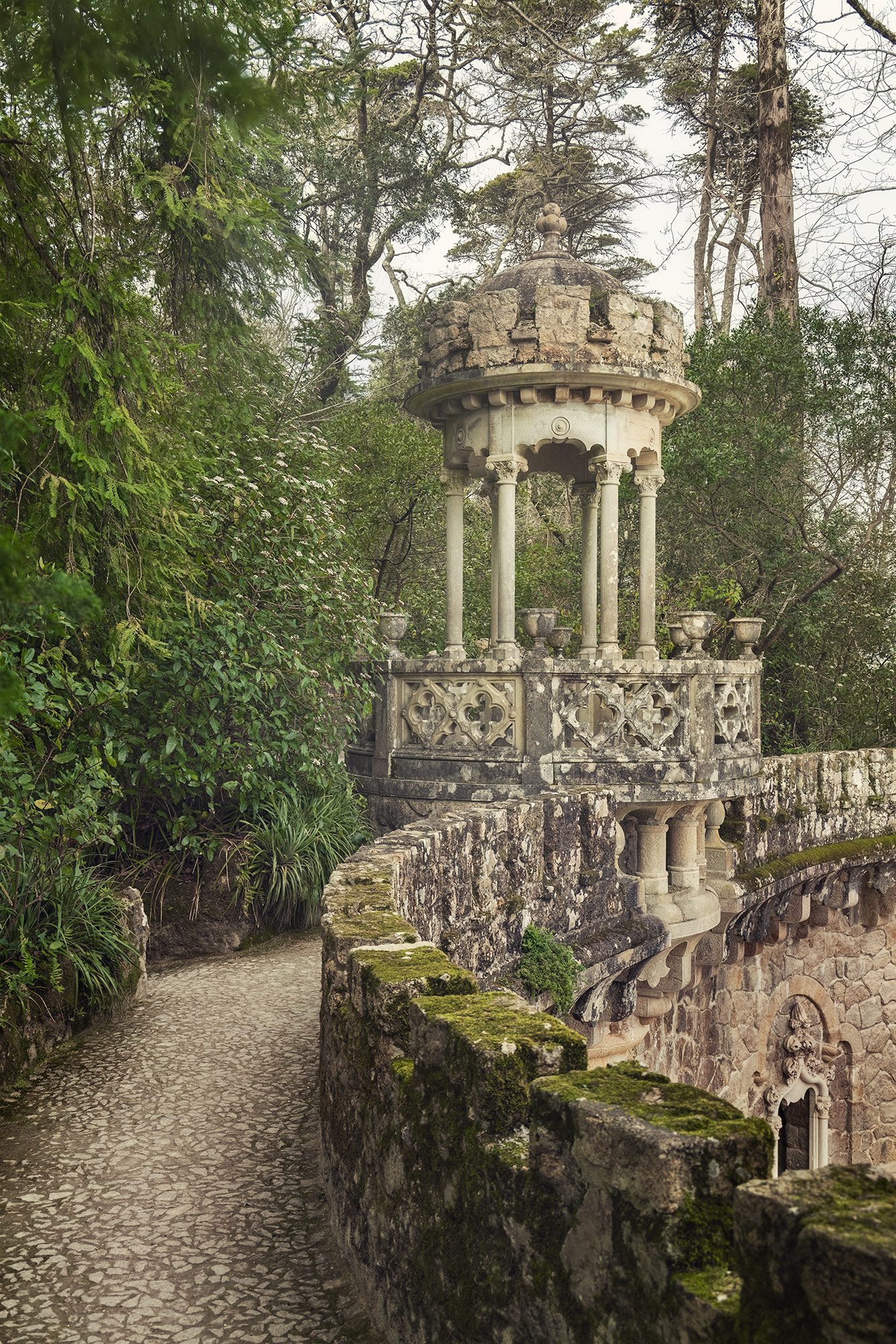 Steinerner Rundpavillon auf einer moosbewachsenen Terrassenmauer in Portugal