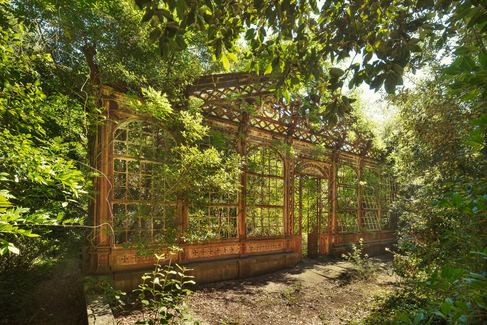 Von Bäumen umschlossenes Gewächshaus aus Eisen und Glas in Italien