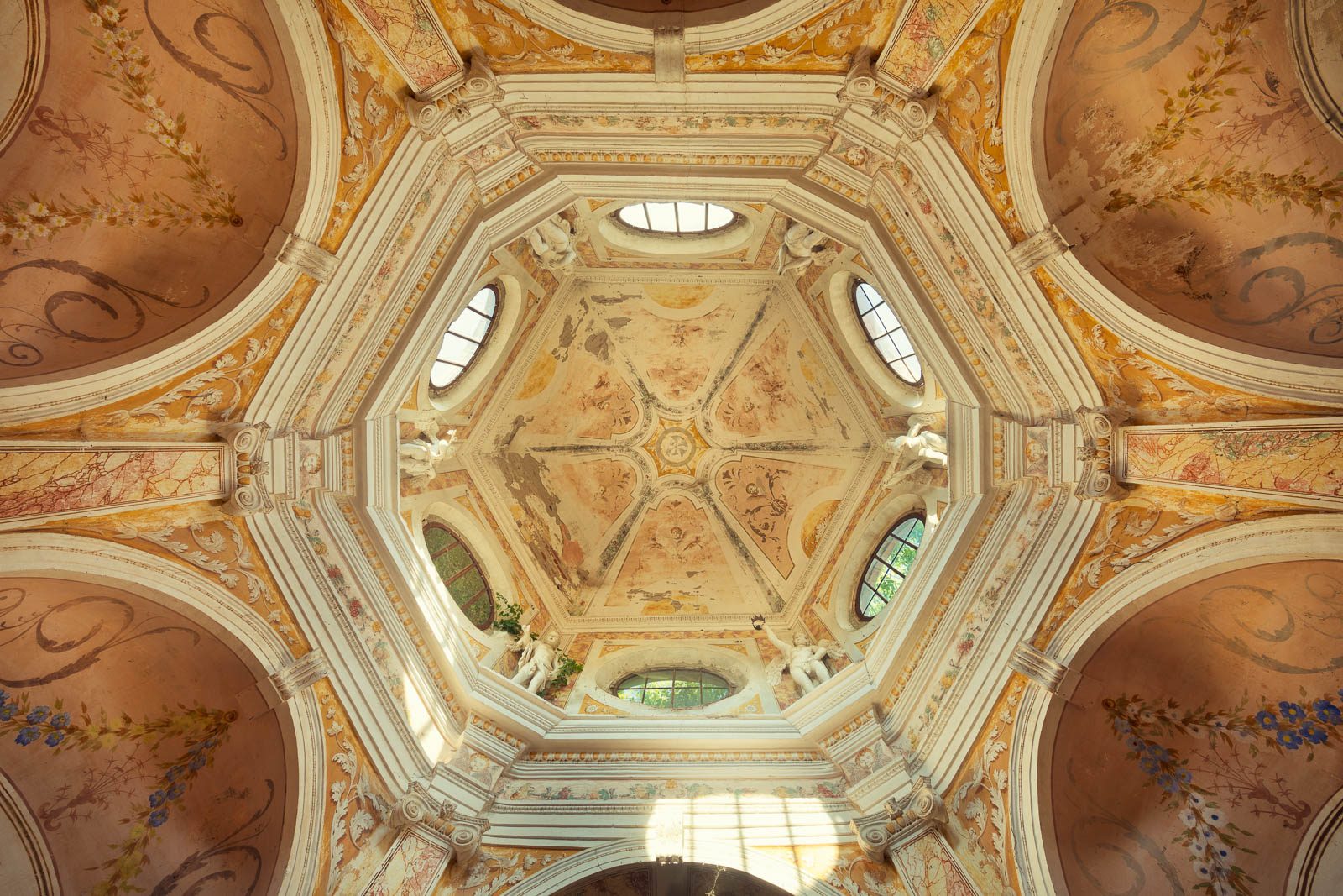 An octagonal frescoed dome with figure niches in an abandoned chapel in Italy
