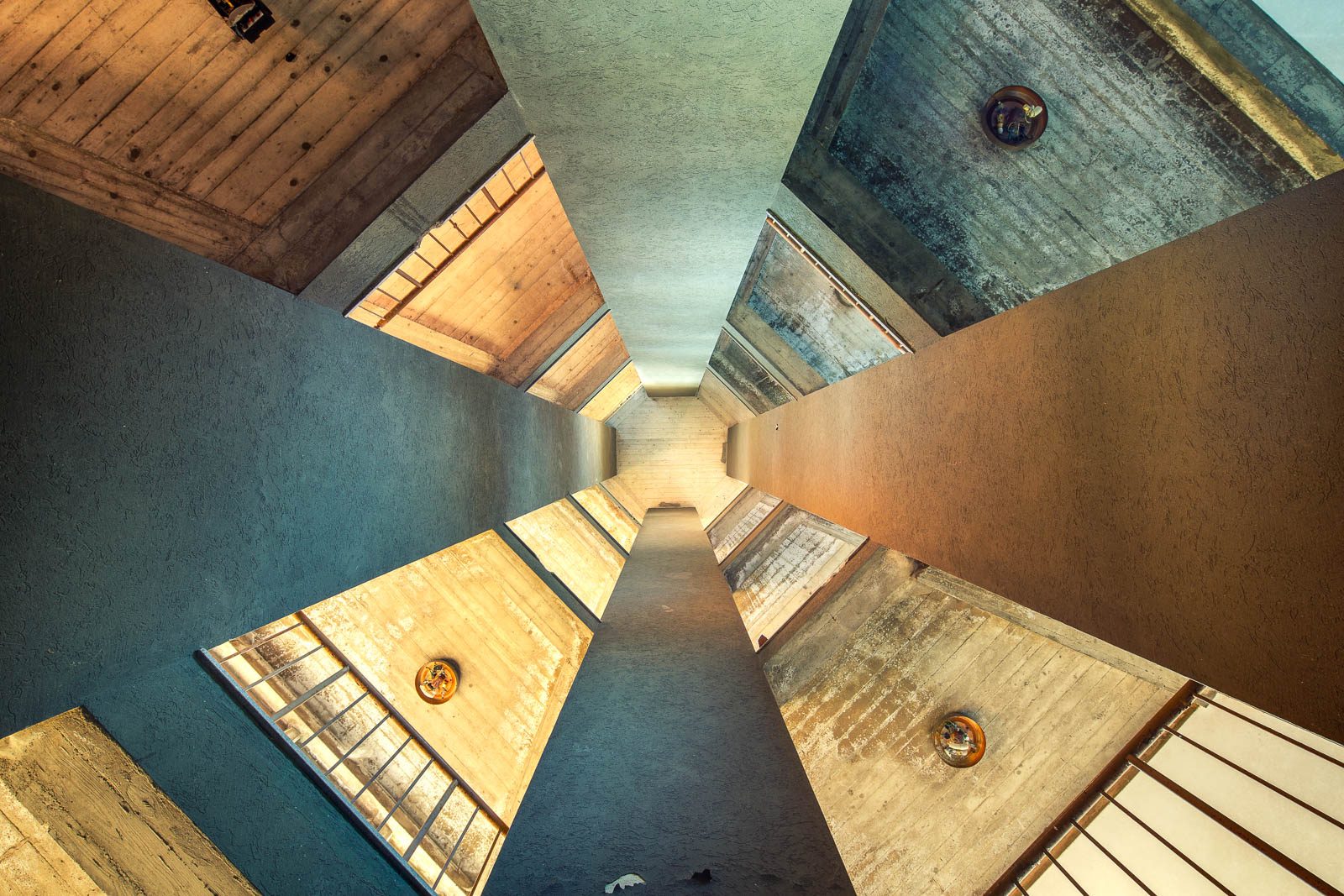 A narrow light well with facing window openings in an abandoned holiday camp in Italy