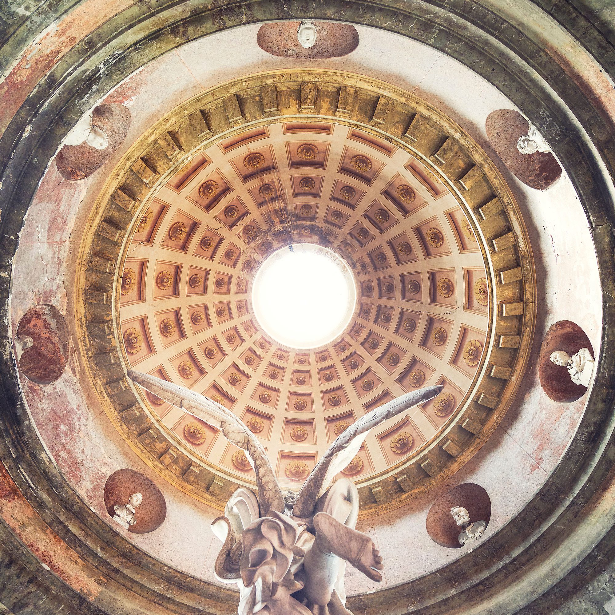 Coffered dome with an angel figure above a monumental cemetery complex in Italy