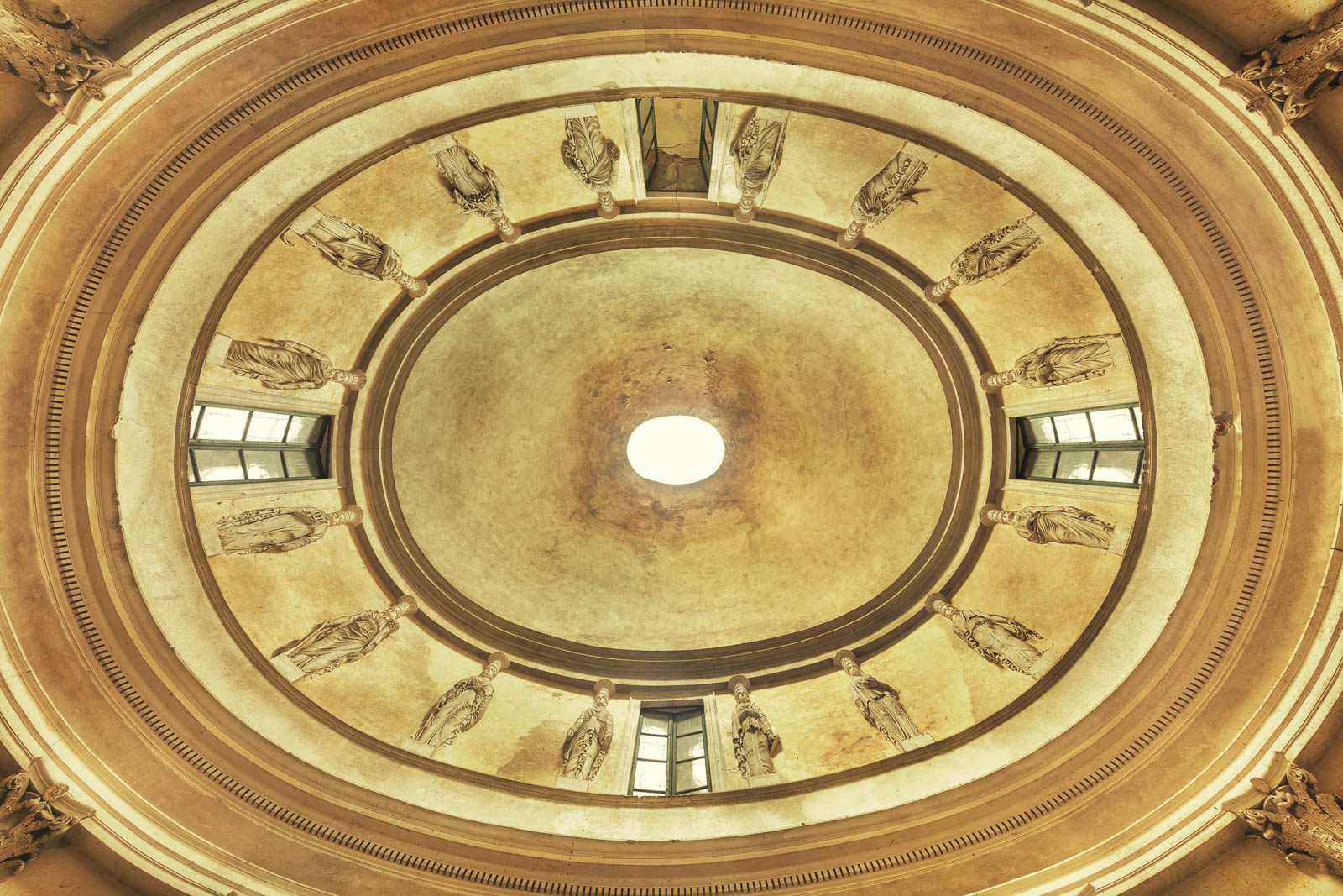 Oval dome with painted figures in niches inside an abandoned villa in Italy